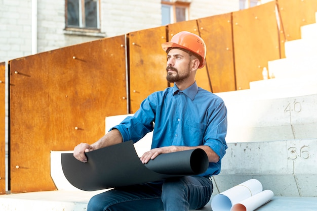 Free photo medium shot of man with helmet and schematics