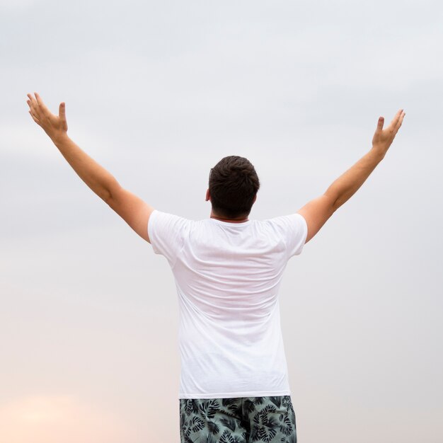 Medium shot of a man with his arms in the air