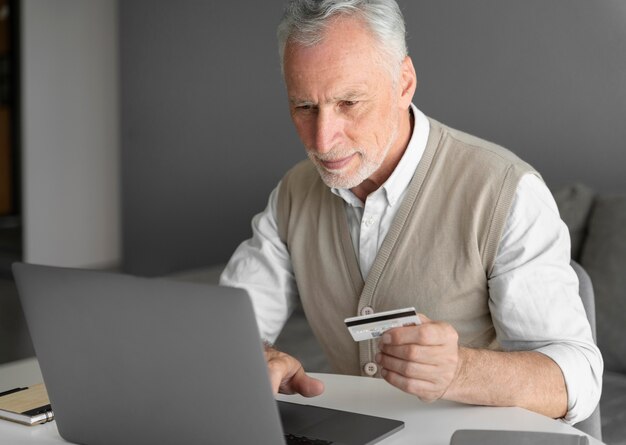 Medium shot man with laptop and card