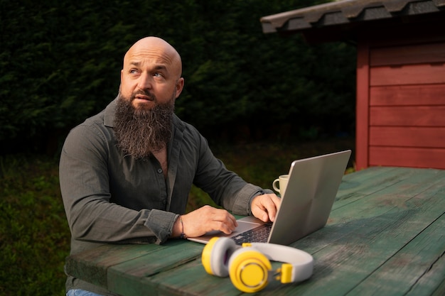 Medium shot man with laptop outdoors