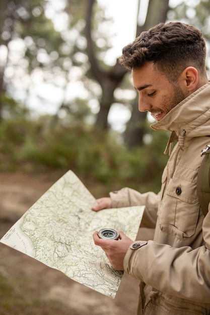 Free photo medium shot man with map and compass