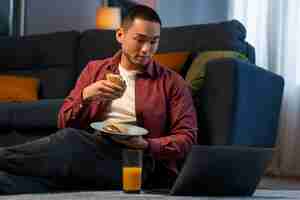 Free photo medium shot man with  paper-wrapped sandwich