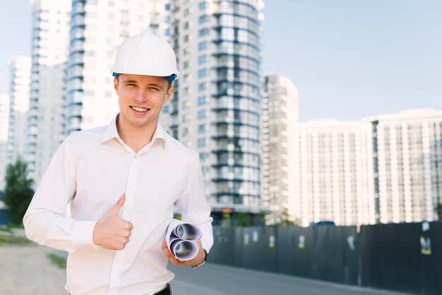 Medium shot man with plans showing approval