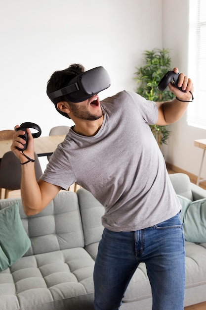 Medium shot man with vr glasses playing