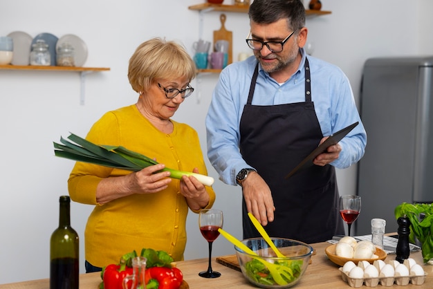 Foto gratuita uomo e donna del piano medio che cucinano in cucina