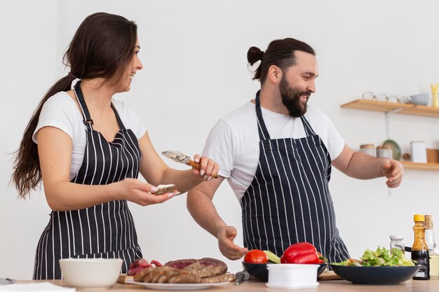 Medium shot man and woman cooking