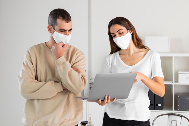 Medium shot man and woman looking at laptop