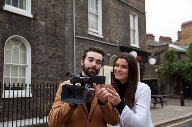 Medium shot man and woman with camera