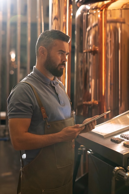 Uomo di tiro medio che lavora nella fabbrica di birra