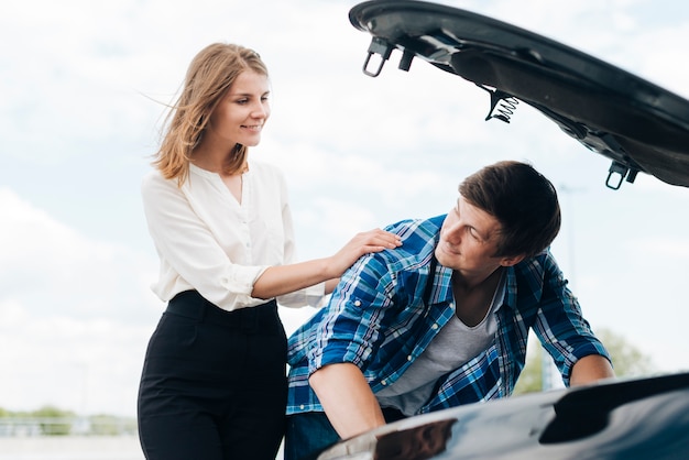 Medium shot of man working on car