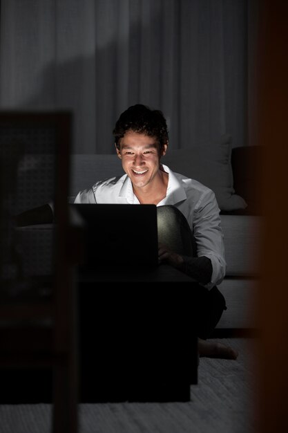 Средний снимок человека, работающего дома в ночное время