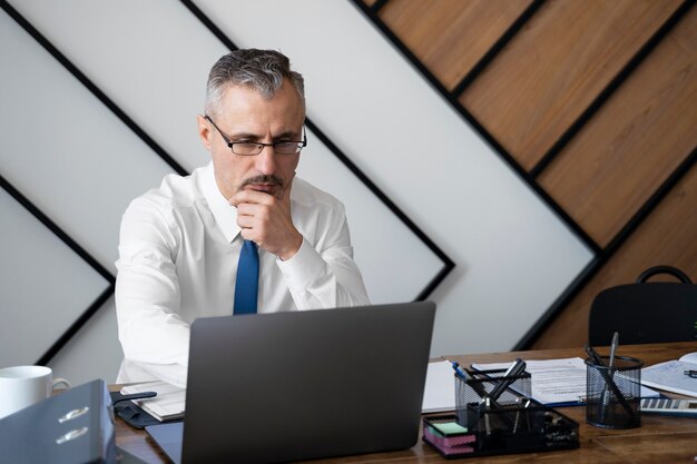 Medium shot man working on laptop