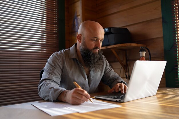 Medium shot man working on laptop