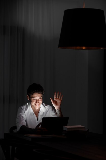 Medium shot man working at night with device