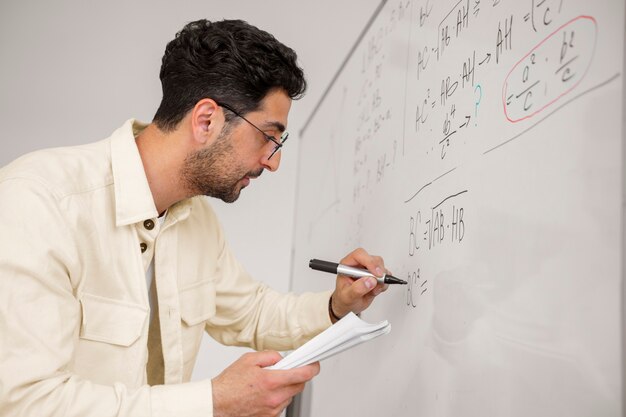 Medium shot man writing on whiteboard