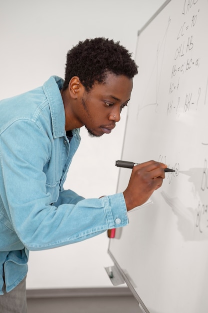 Free photo medium shot man writing on whiteboard