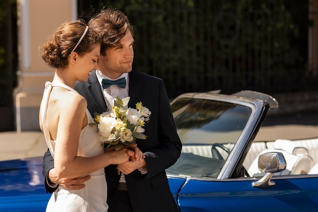 Free photo medium shot married couple near car