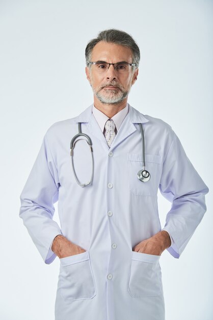 カメラ目線のポケットに腕を持って立っている医療専門家のミディアムショット
