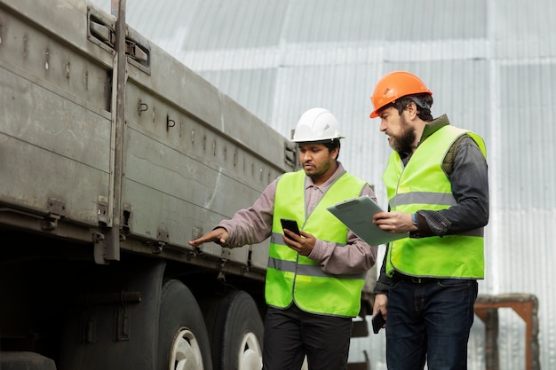 Medium shot men checking truck