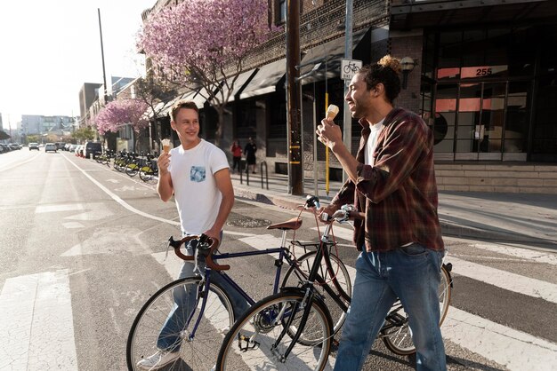 Free photo medium shot men couple eating ice cream