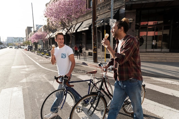 Medium shot men couple eating ice cream