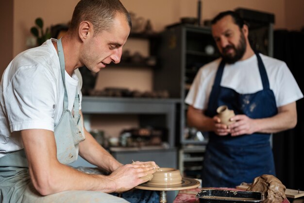 Medium shot men doing pottery