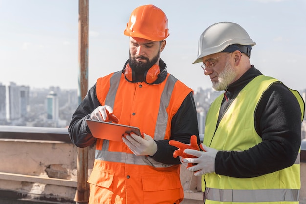 Medium shot men looking at tablet