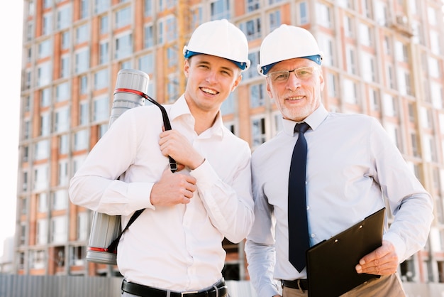 Medium shot men with helmets looking at camera