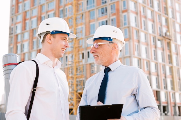 Free photo medium shot men with helmets looking at each other