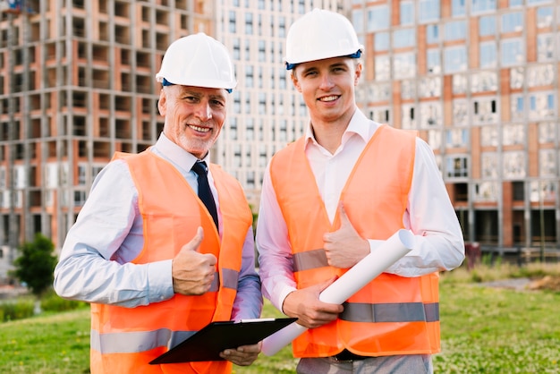 Medium shot men with safety vests showing approval