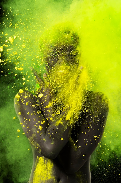 Free photo medium shot model posing with yellow powder