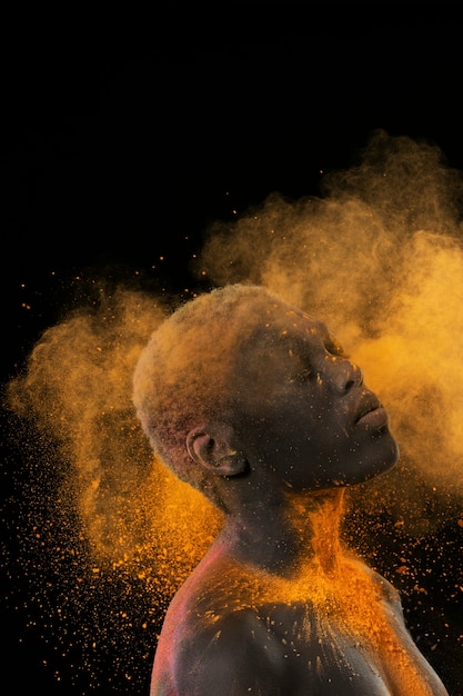 Free photo medium shot model posing with yellow powder