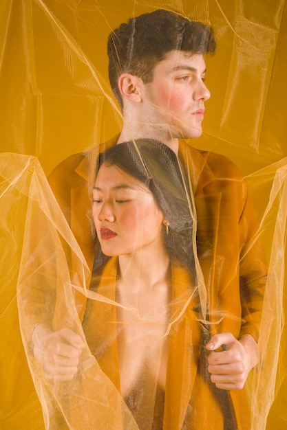 Free photo medium shot models posing with transparent fabric