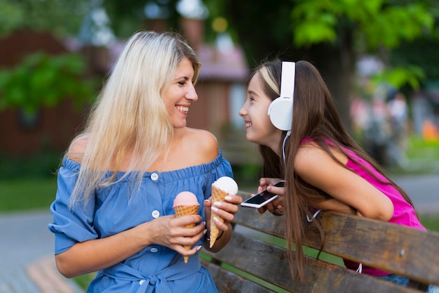 Medium shot of mom and daughter with ice cream