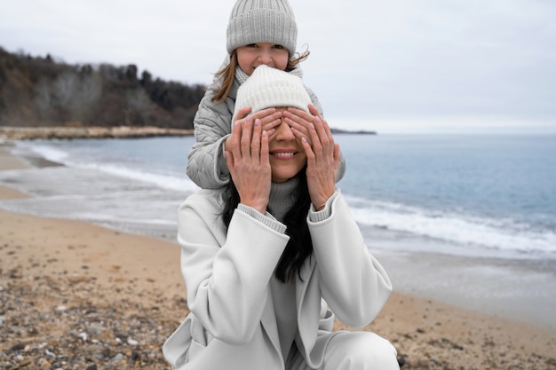 무료 사진 중간 샷 어머니와 해변에서 아이