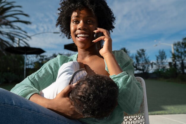 Medium shot mother breastfeeding baby outside