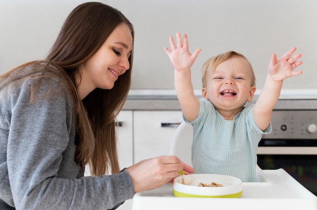 ミディアムショットの母親が子供を養う