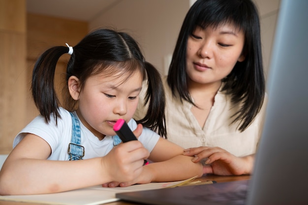 Medium shot mother and girl at desk