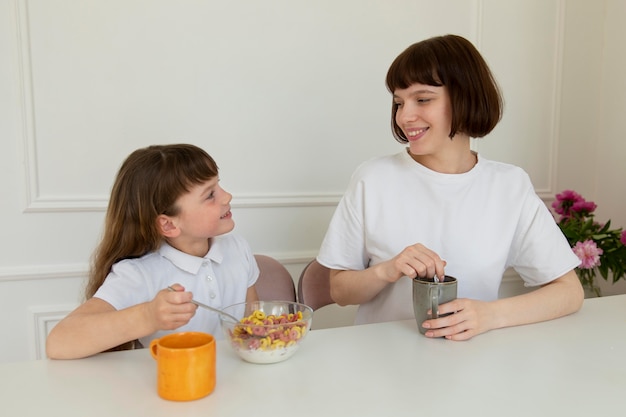 Medium shot mother and girl at table