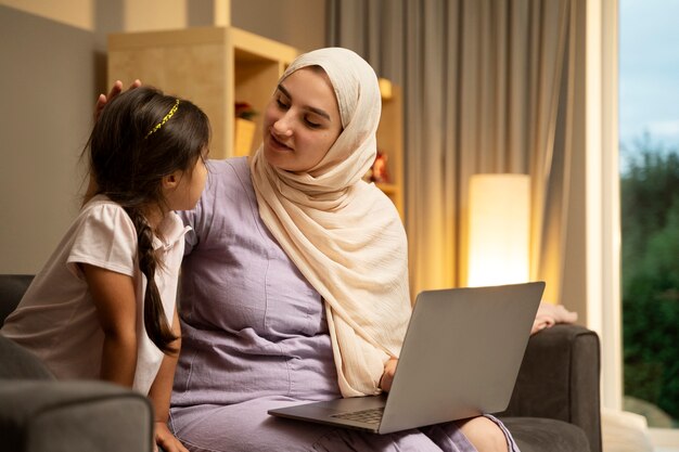 Medium shot mother and girl with laptop