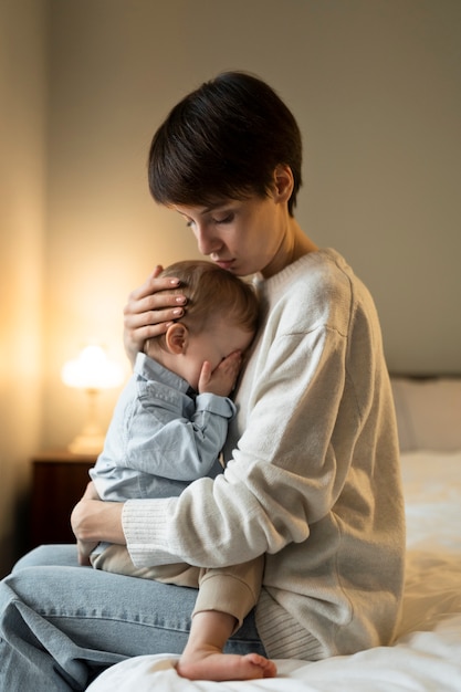 Medium shot mother hugging baby