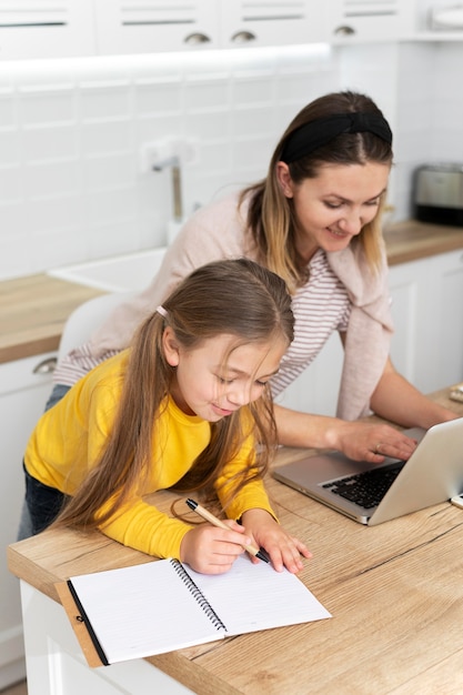 Medium shot mother and kid at desk