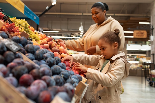 Foto gratuita colpo medio madre e figlio al mercato