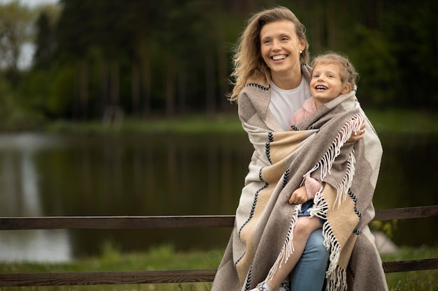 Free photo medium shot mother and kid with blanket