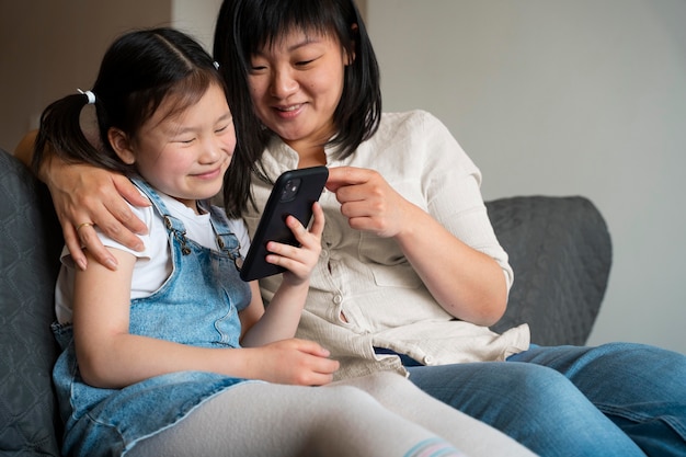 Medium shot mother and kid with phone