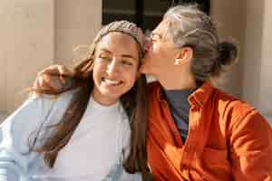 Free photo medium shot mother kissing daughter on head