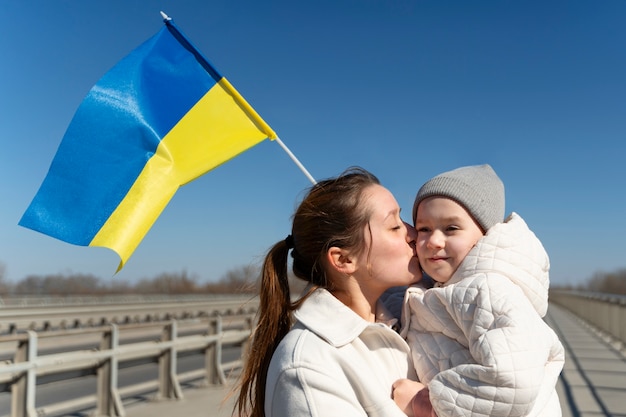 Free photo medium shot mother kissing little kid