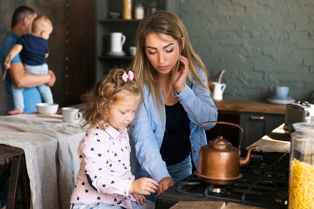 Foto gratuita madre del colpo medio che produce tè con la figlia