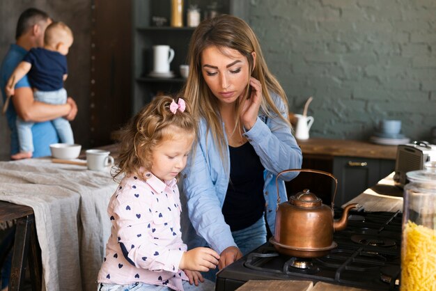 Medium shot mother making tea with daughter