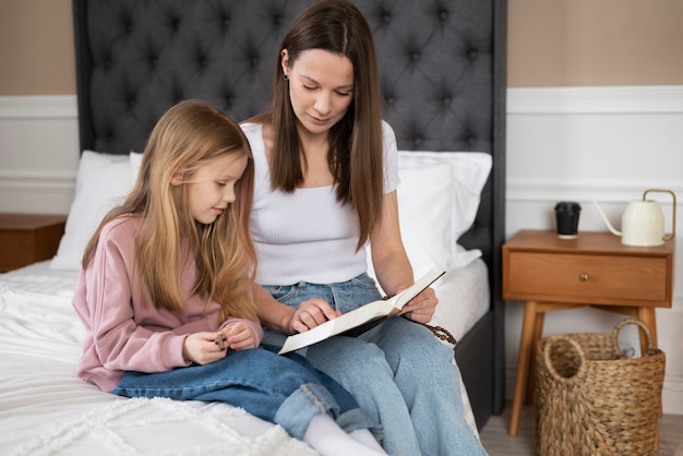 Medium shot mother reading to daughter